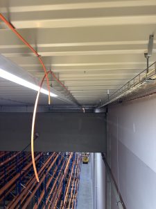 Trasování kabelů pro opticko-kouřové hlásiče na stropní konstrukci-Skladová hala-D (SEGRO)